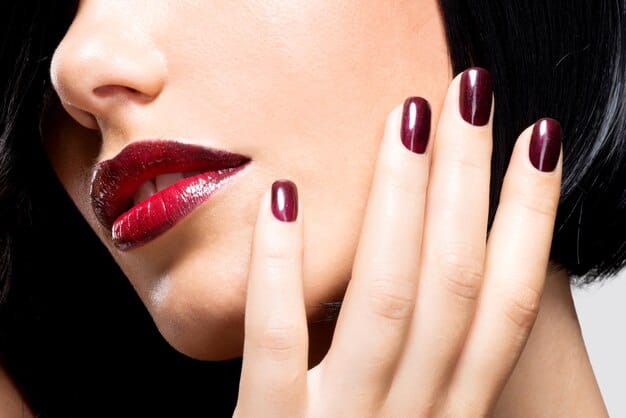 woman with beautiful dark red nails