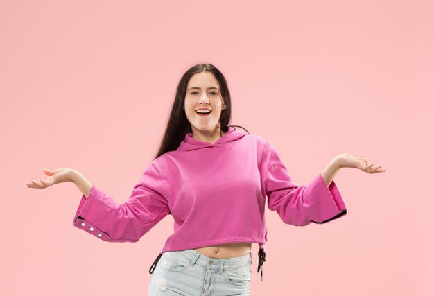 Happy business woman standing smiling in pink studio