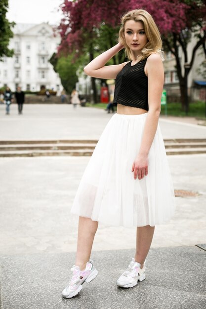 Woman outdoors look in white skirt and black top