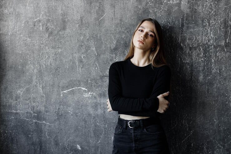 woman posing in black jeans with black top