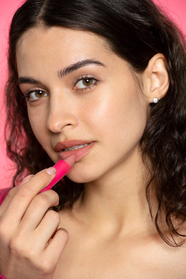 side view woman using nude lipstick