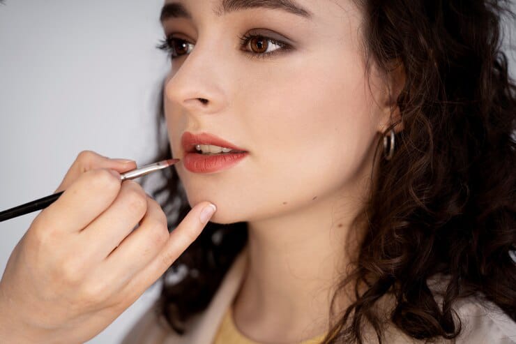 makeup artist setting lip with brown lip liner