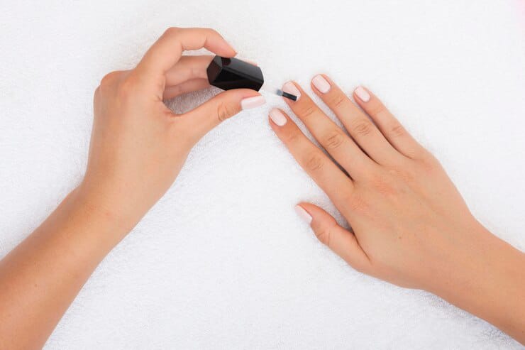 Girl applying white nail polish image