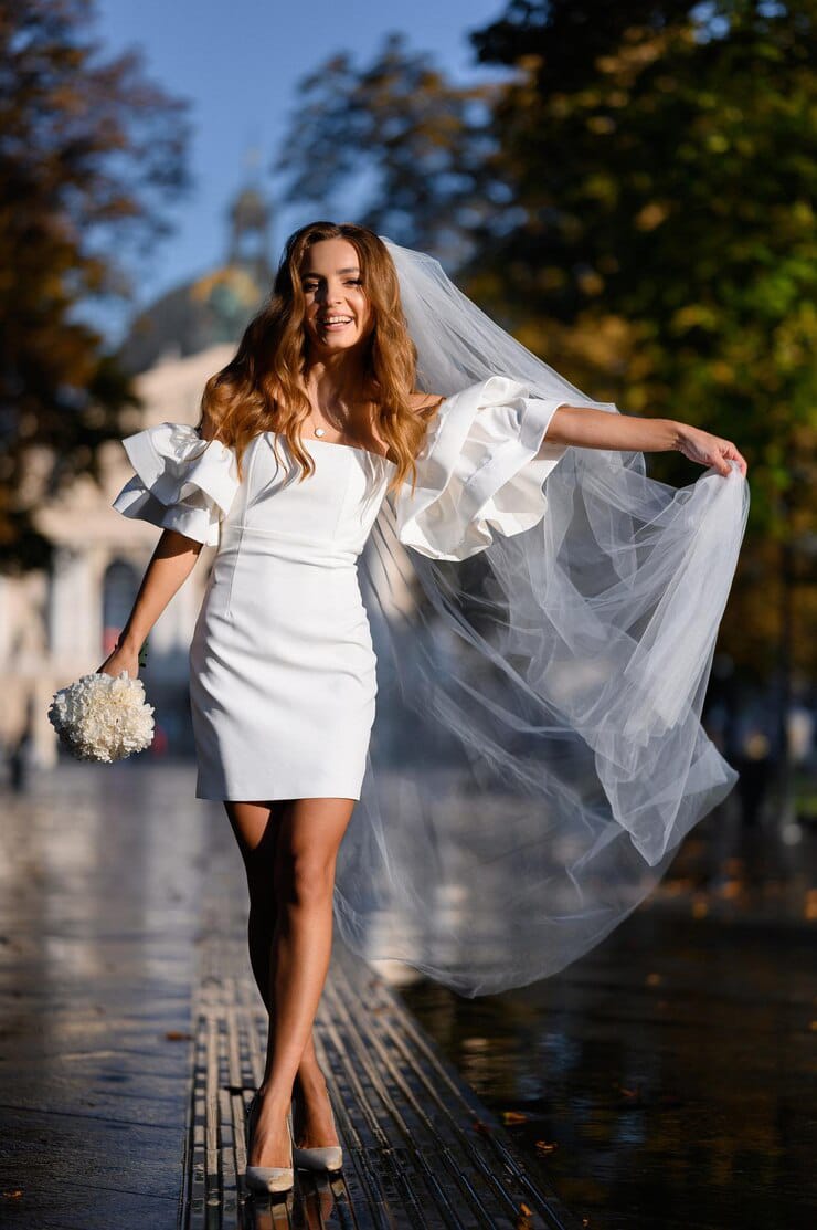 front view smiling woman wedding short gown holding white flower