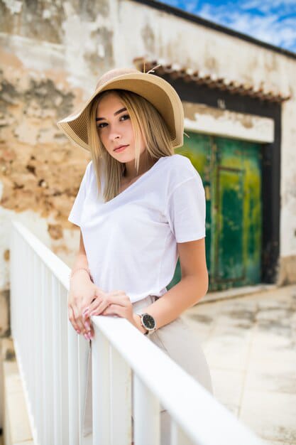 beautiful woman looking outdoor posing look wearing plain white tee and beige slacks with hat