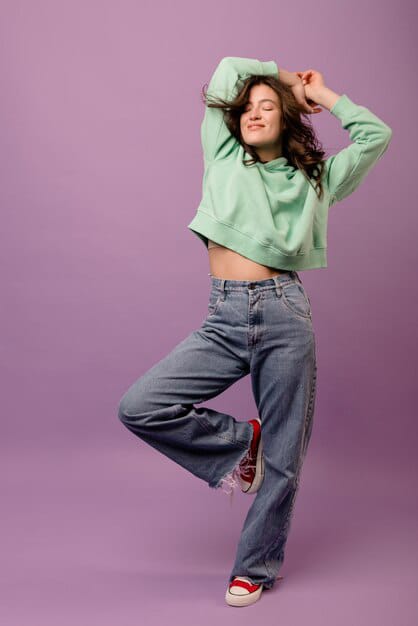 young woman posing in mint cropped sweater with high waist jeans