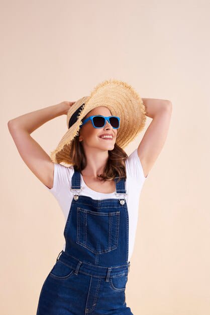 happy woman wearing denim dress with straw hat looking beautiful