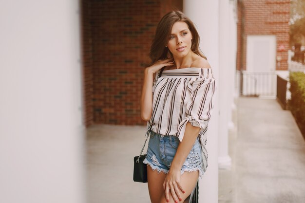 posing young woman striped top with denim shorts