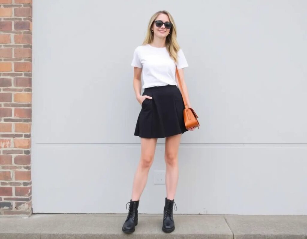 young smiling women wearing simple white tee black skirt with combat boots