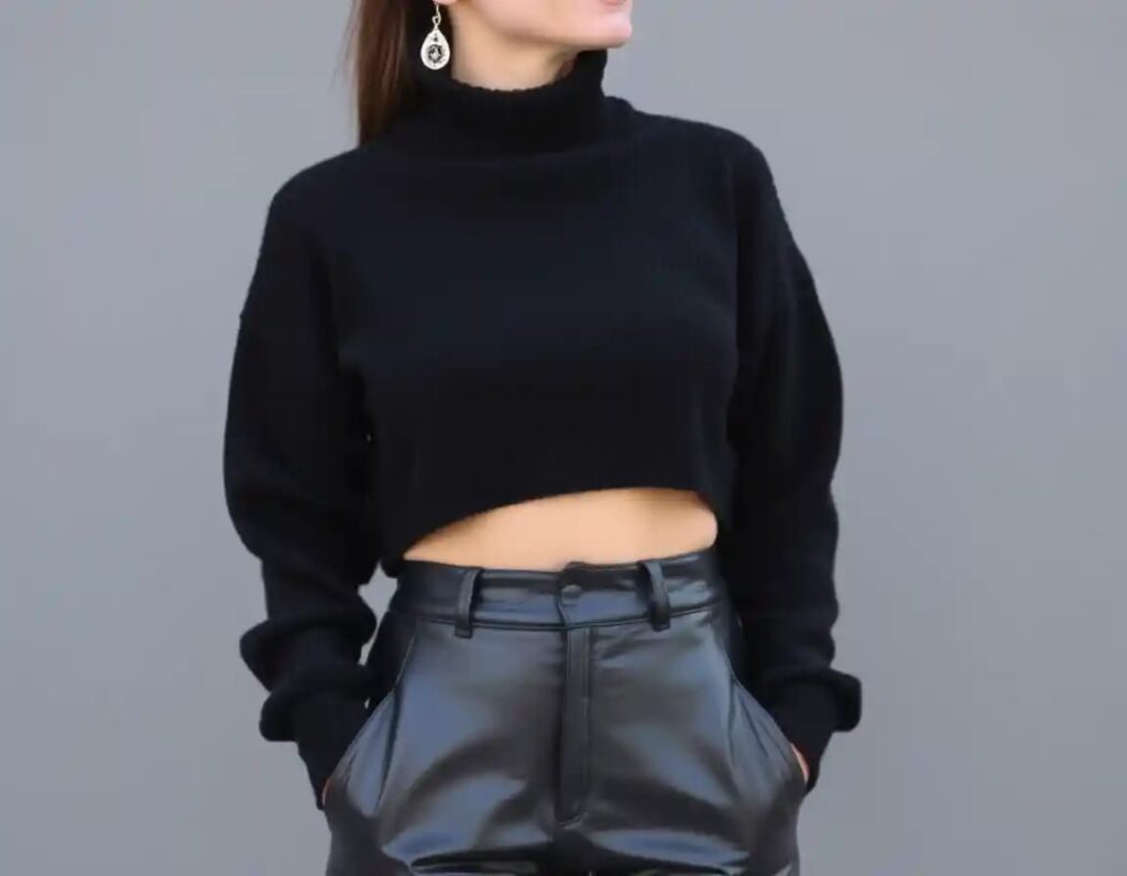 simple woman look in black cropped turtleneck sweater with leather pants